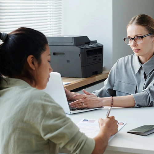 One woman conducts an evaluation for Immigration Exams with another woman